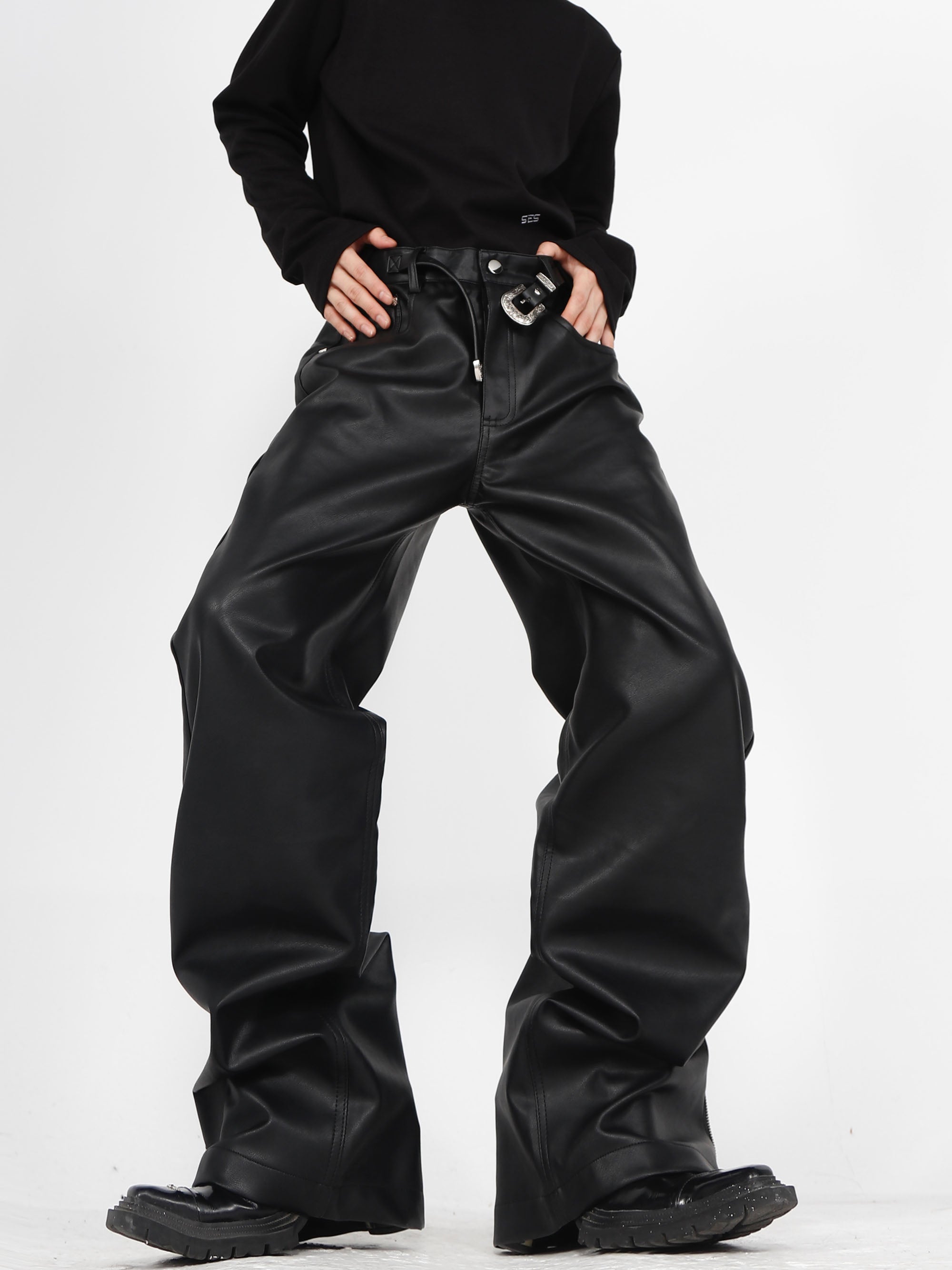 Edgy PU leather pants with statement metal buckles and flared legs, perfect for streetwear fashion