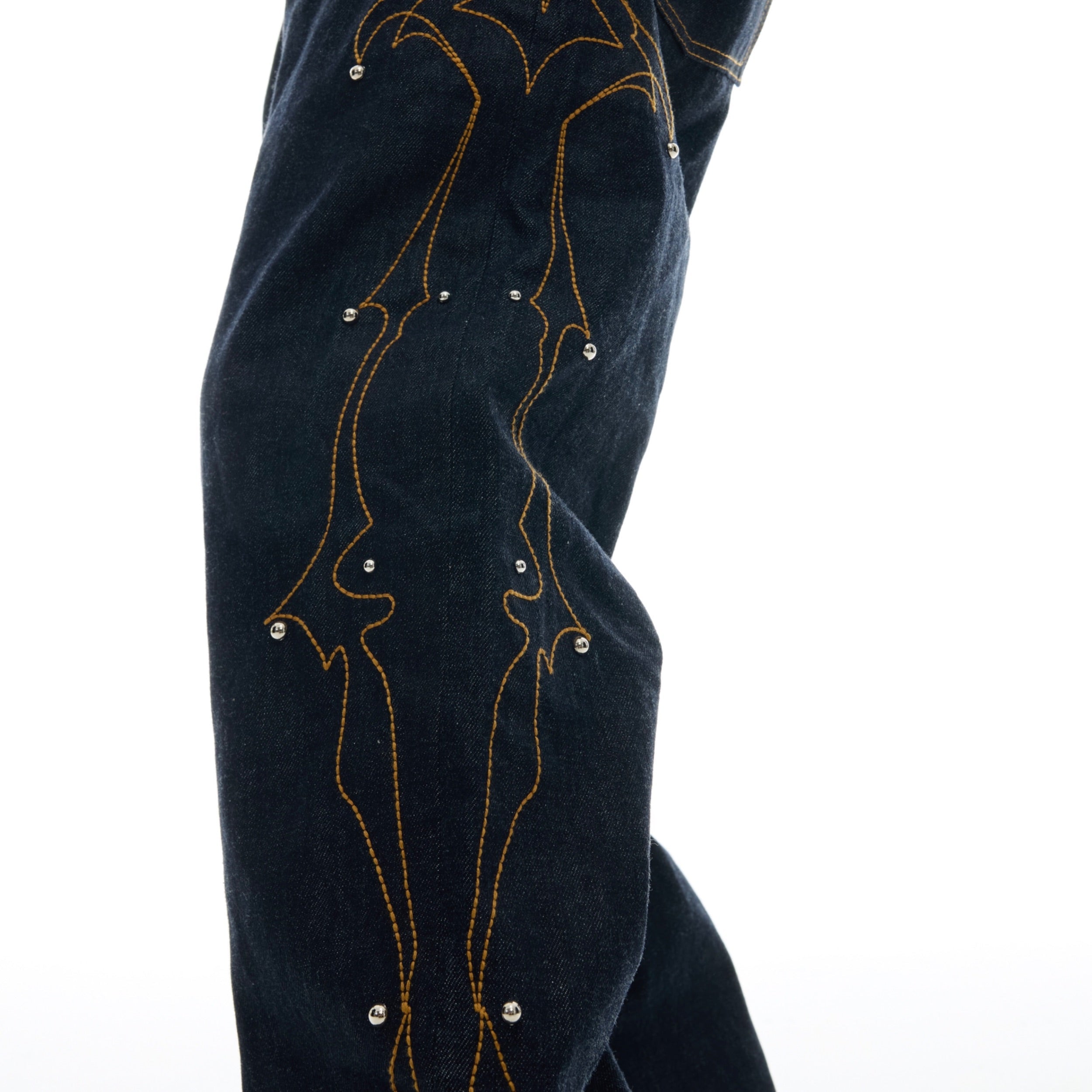 Side profile of retro flared jeans highlighting the handcrafted embroidery details and beaded embellishments