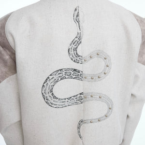 Back view showing avant-garde patchwork design and embroidery on snake print cropped streetwear jacket