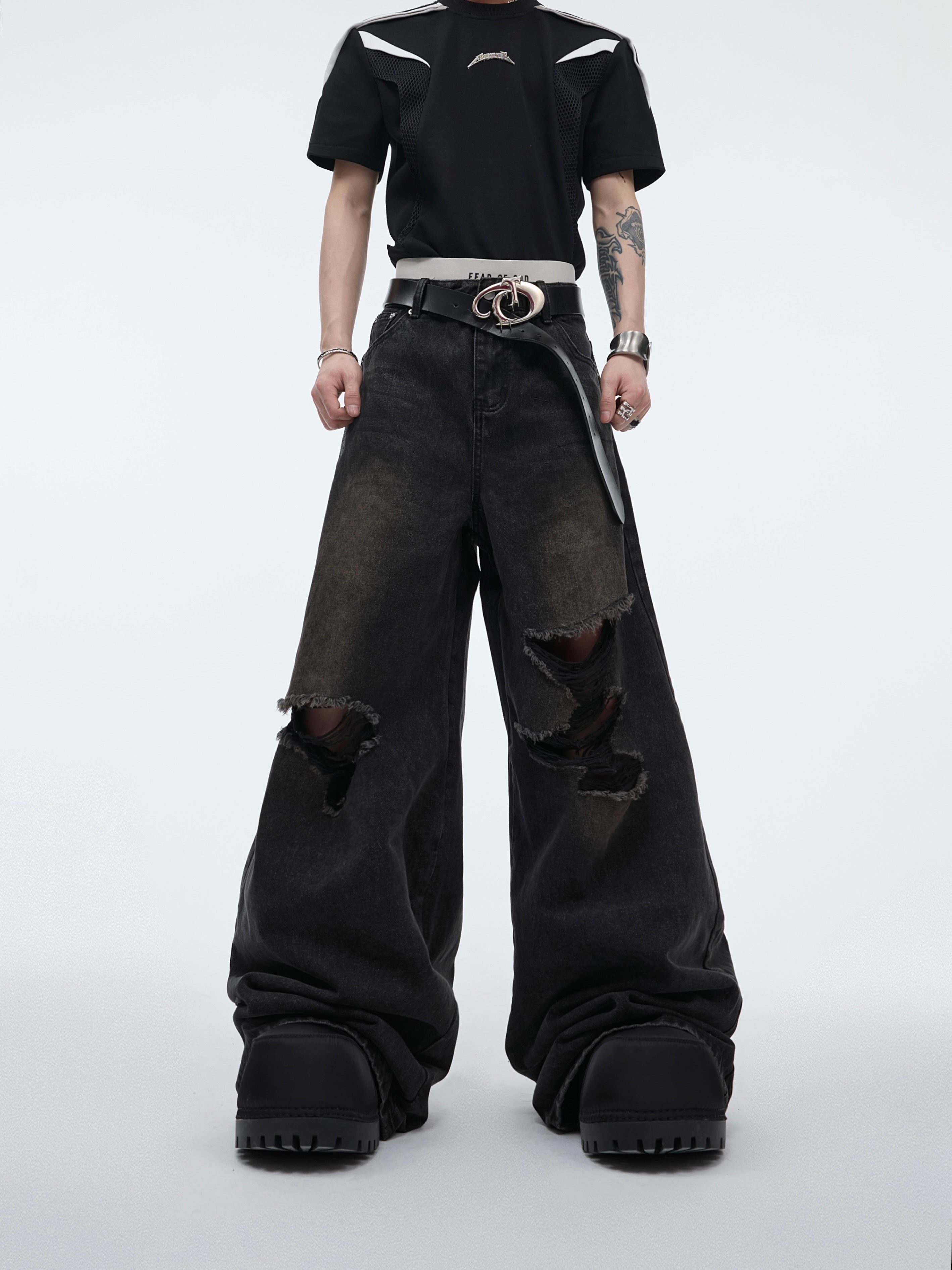 Front view of deconstructed ripped flare jeans featuring intricate dragon embroidery, streetwear fashion statement