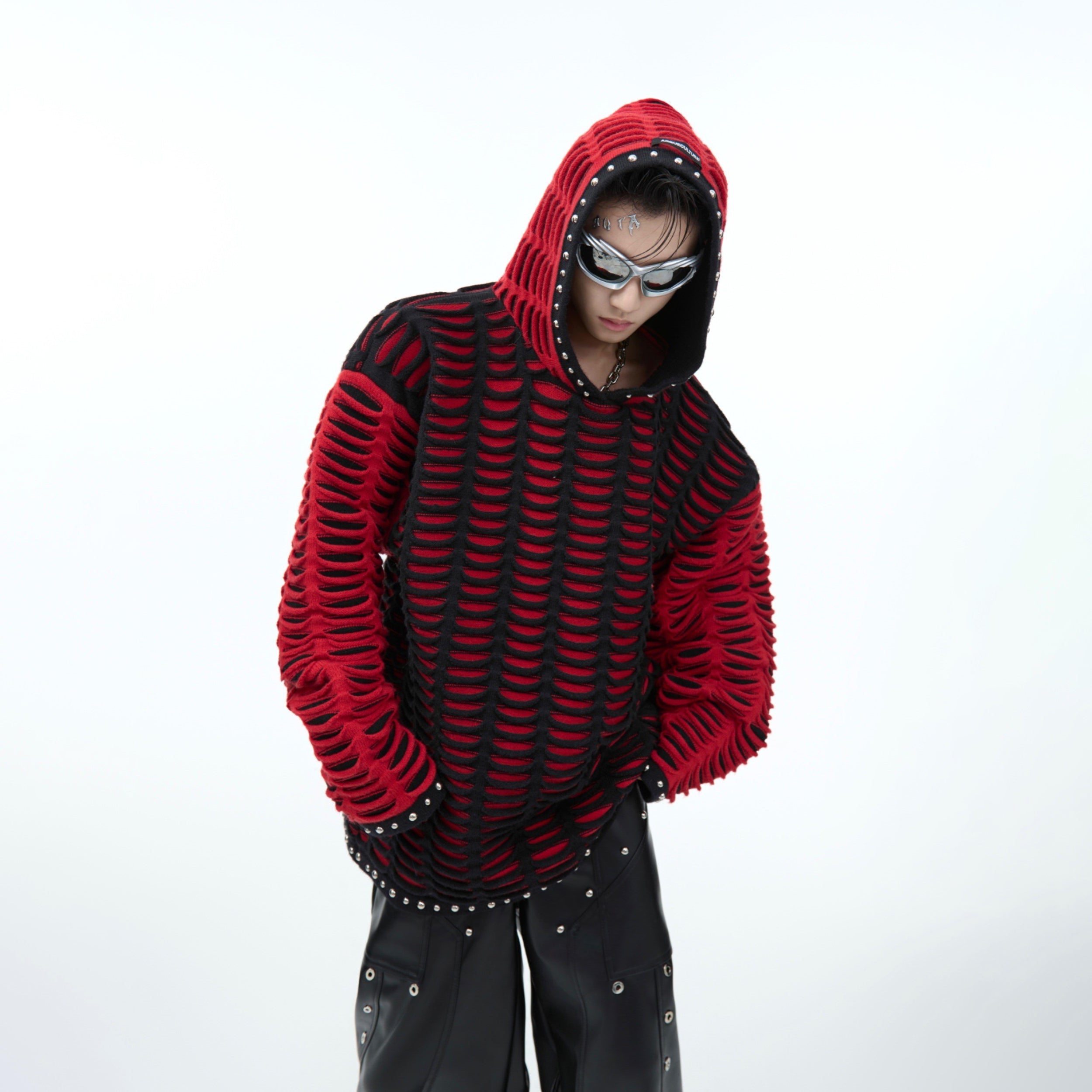 Back view showing unique patchwork design and ripped details on oversized hooded sweater, urban winter fashion