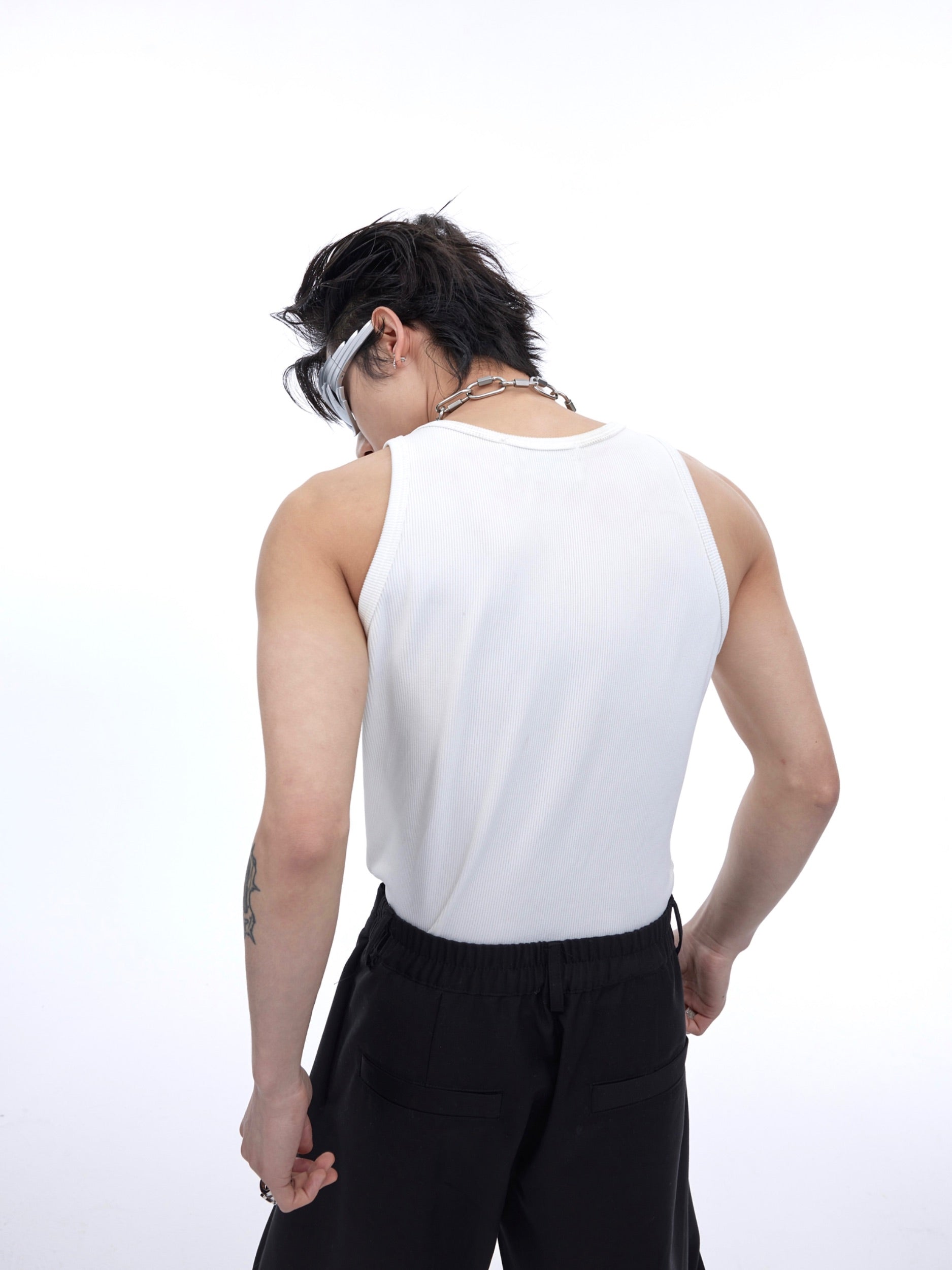 Deconstructed gender-neutral vest showing raw-edge detailing on the sleeveless muscle tank