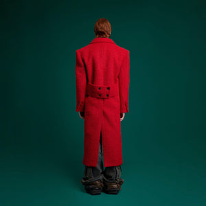 Back view of the statement wool coat showing its dramatic oversized silhouette and split hem details