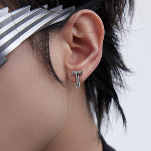 Close-up of edgy T-shaped lava design earrings showing unique deconstructed metal texture and contemporary style