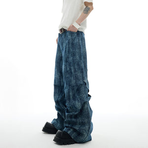 Side profile of distressed straight-leg jeans highlighting the unique patchwork design and fit