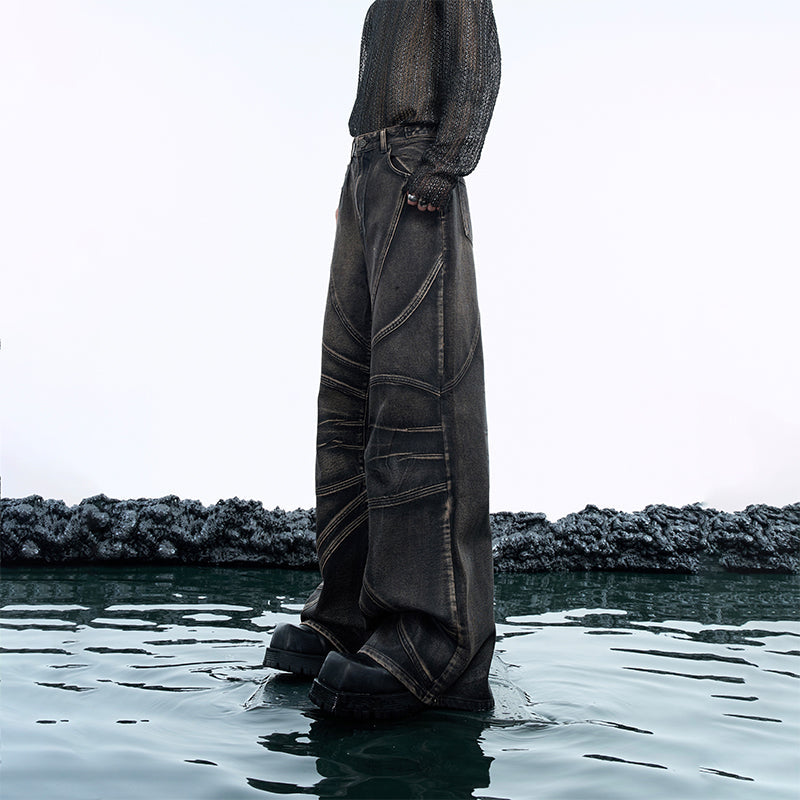 Vintage distressed denim jeans with relaxed flare fit showing artful distressing and heavy wash details