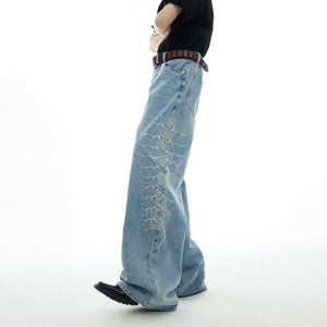 Front view of vintage washed denim jeans featuring unique snake-eye studs and distressed detailing