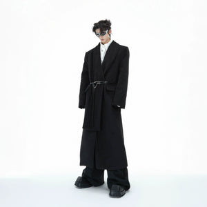 Deconstructed wool trench coat with metal strap details, showcasing the oversized silhouette and leather accents