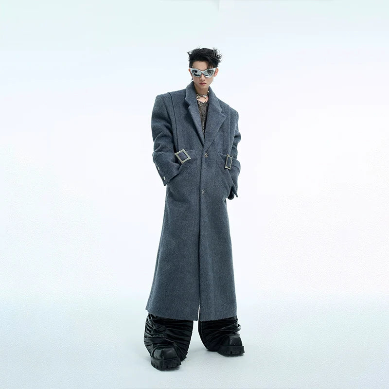 Front view of oversized wool coat with deconstructed waist design, featuring metal buttons and loose belted trench style