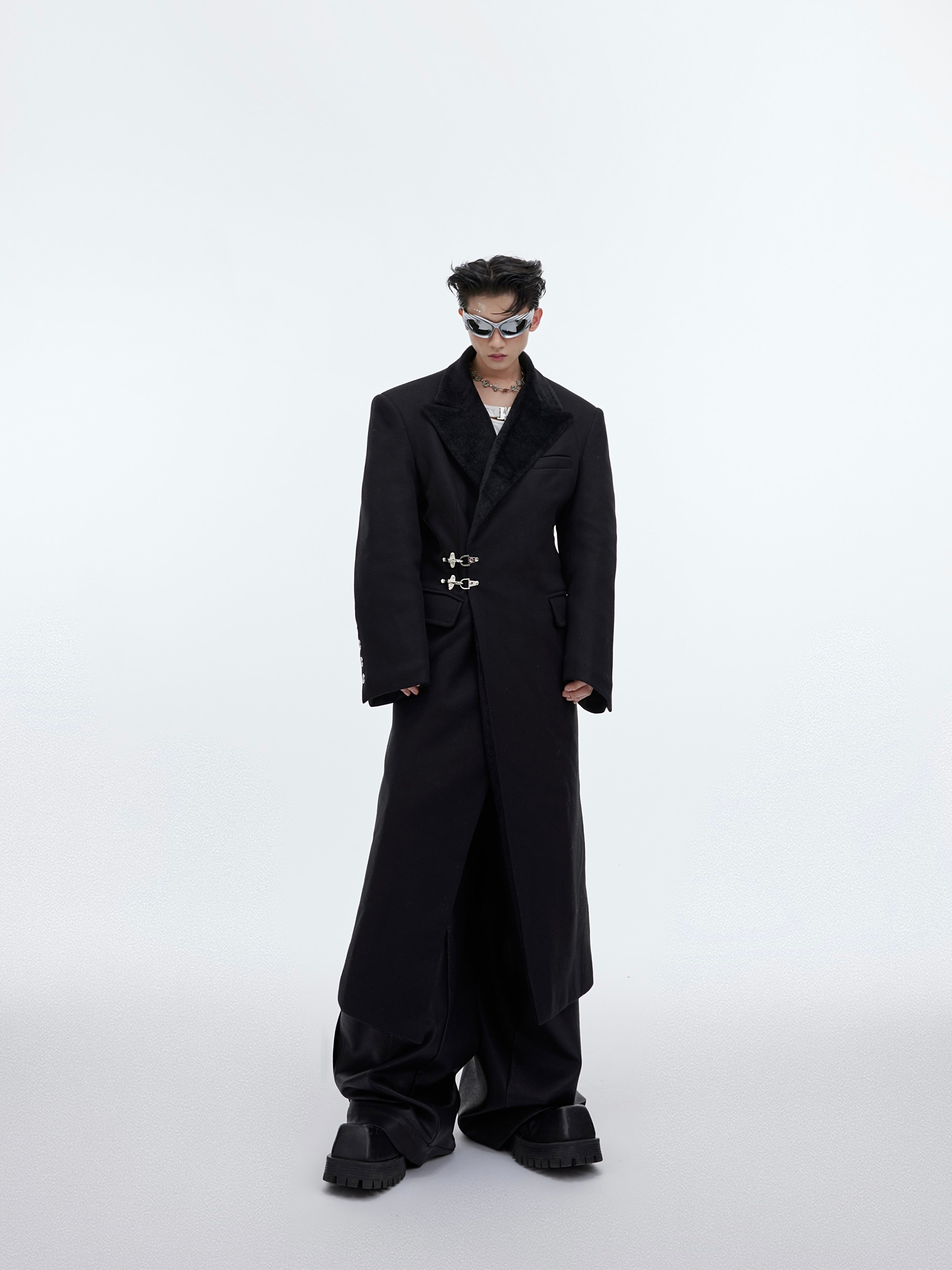 Front view of deconstructed wool trench coat featuring unique metal airplane buckles, perfect for streetwear fashion