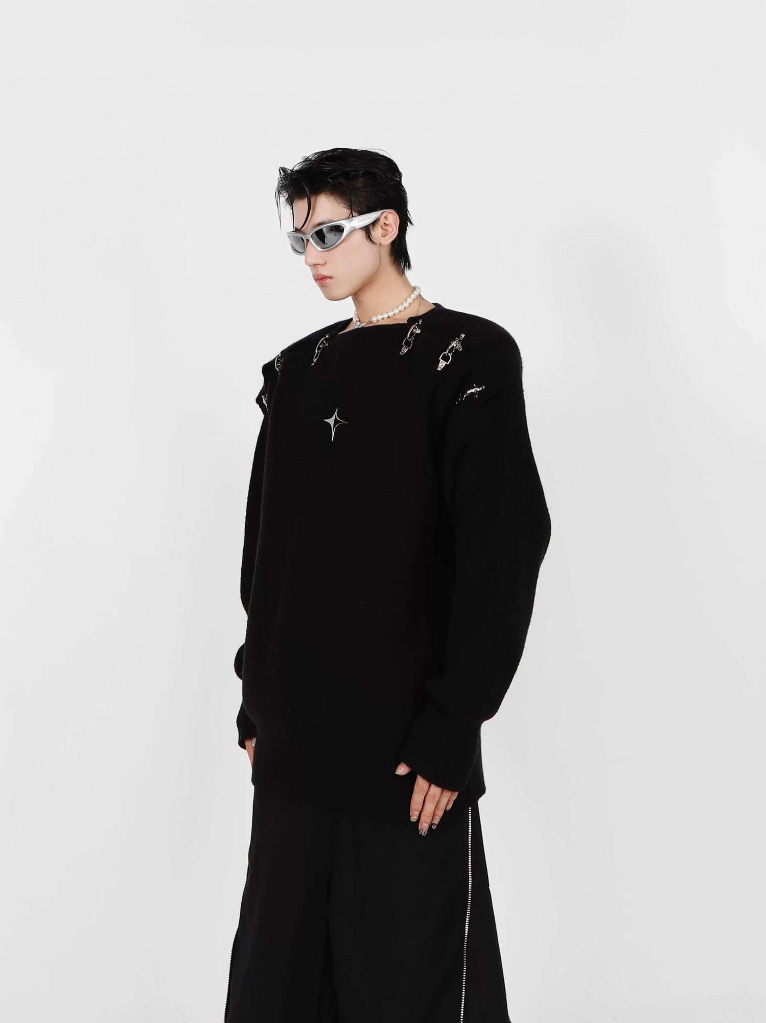 Close-up of the metal buckle and cutout design on gray sweater