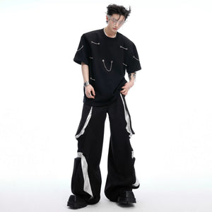 Male model wearing oversized black tee with metal chain detail