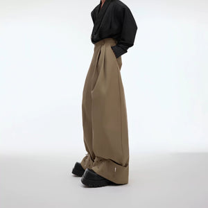 Front view of black wide-leg trousers with metallic rivet accents.