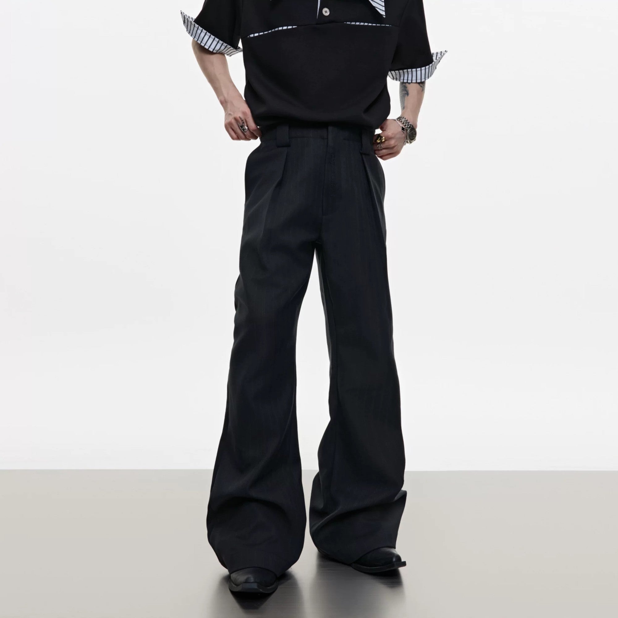 Side view of black flared casual pants showing the bootcut leg opening