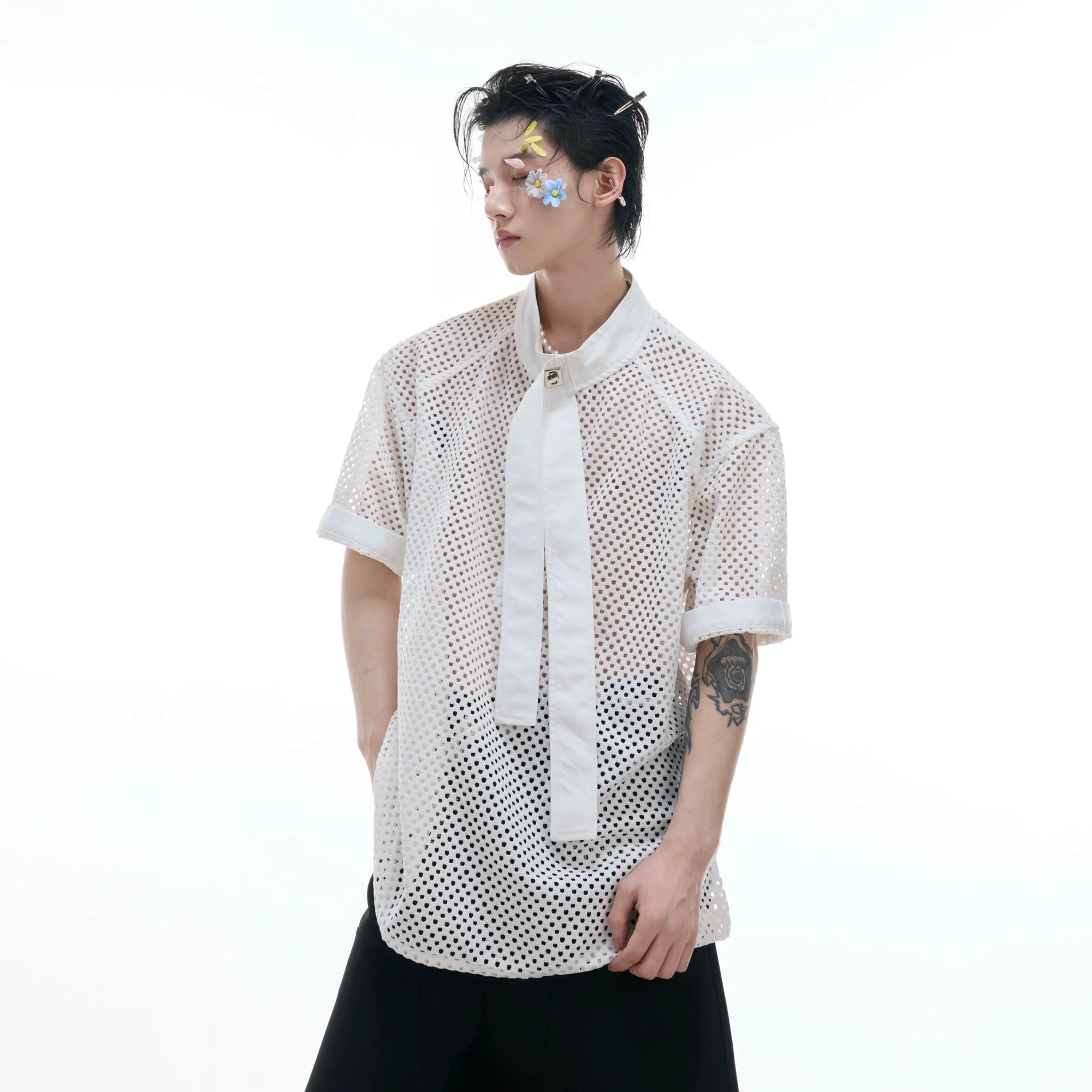 Model wearing white deconstructed hollow-out tee in an urban setting