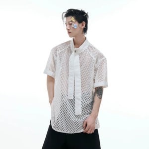 Model wearing white deconstructed hollow-out tee in an urban setting