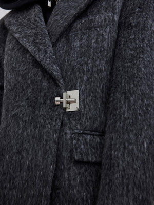 Close-up of the premium metal buckle closure on a wool coat