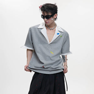 Front view of oversized V-neck polo with colorful sticker prints