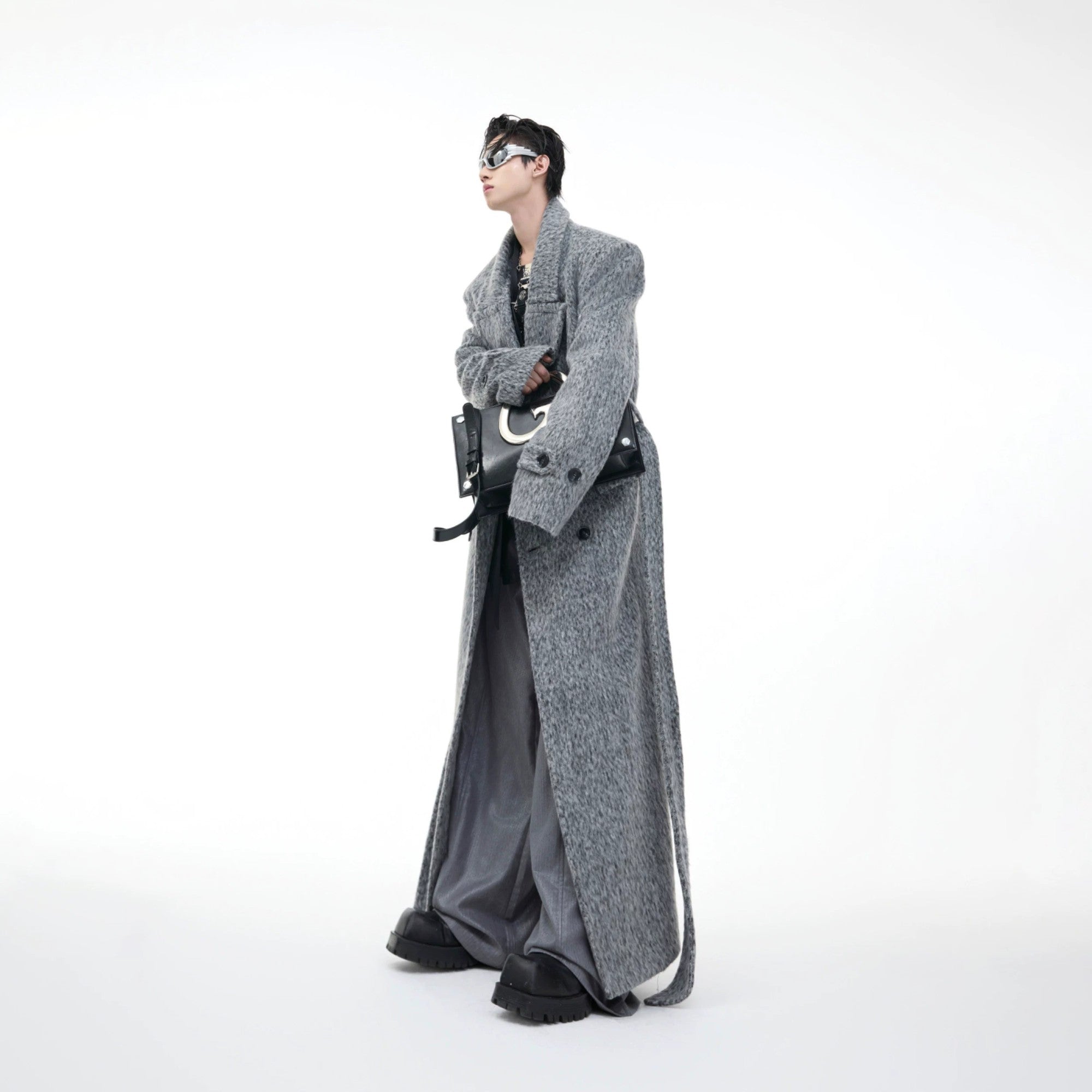 Man wearing oversized dark gray woolen trench coat in street setting