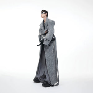 Man wearing oversized dark gray woolen trench coat in street setting