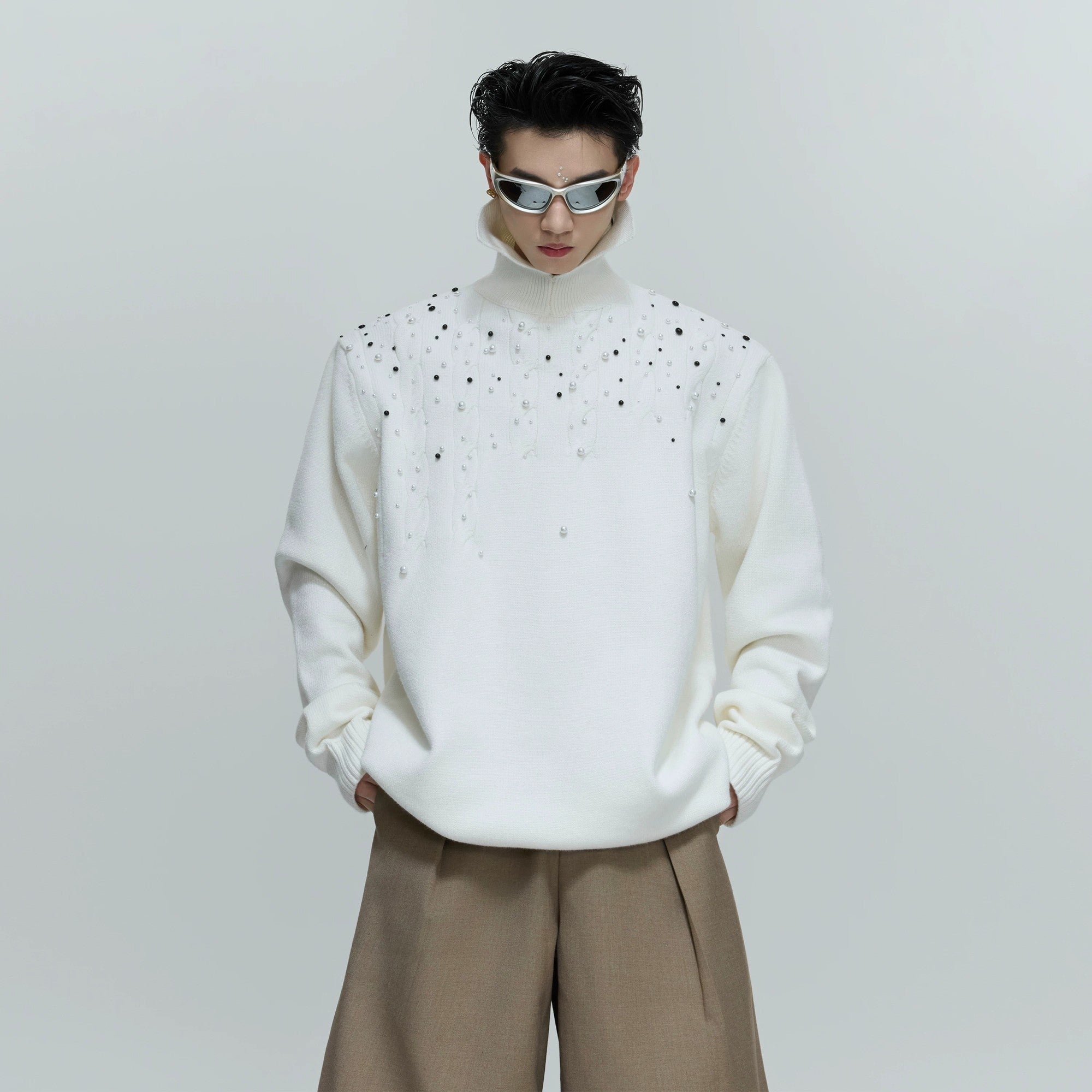 Model wearing white oversized pearl turtleneck in a street setting