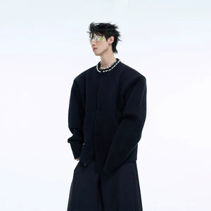 Male model wearing a black cropped pearl cardigan in a street setting