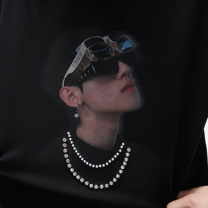 Model wearing black pearl graphic tee in a street setting