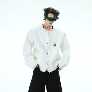 High-polish detachable metal pin on the chest of the cardigan