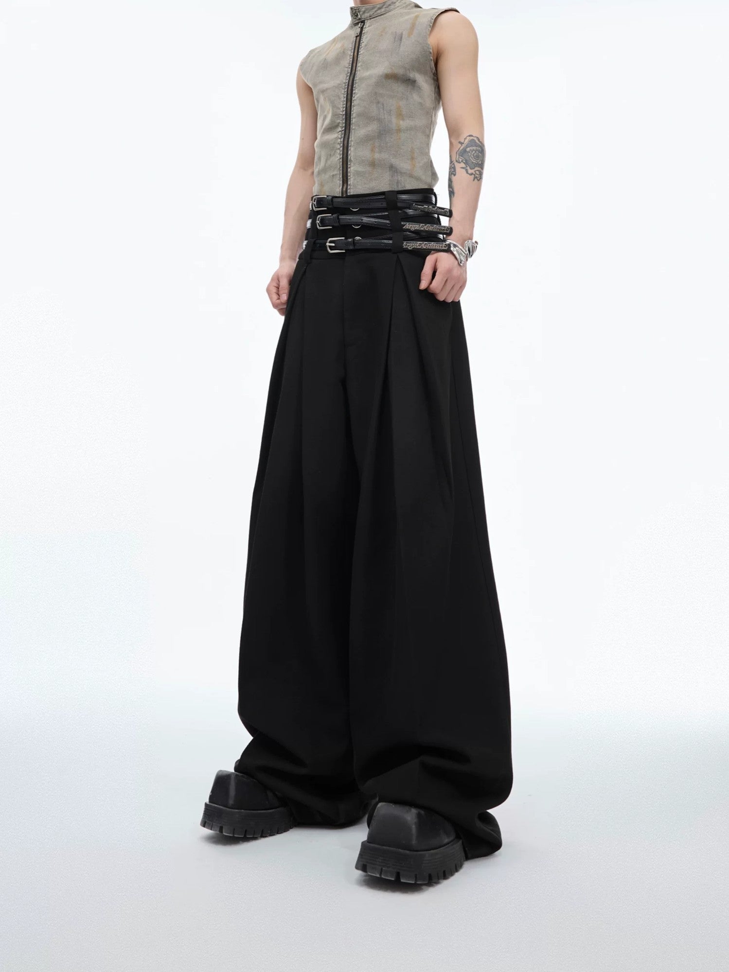 Front view of black pleated straight-leg designer trousers with belt