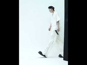 Video showing movement and reflective properties of striped wide-leg pants with pleated texture