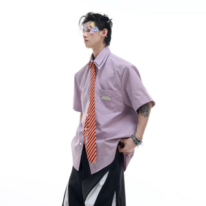 Model wearing white oversized retro tie shirt in a street setting