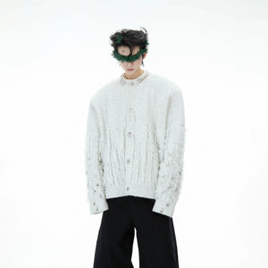 Model wearing a white fringe knit cardigan in a street setting.