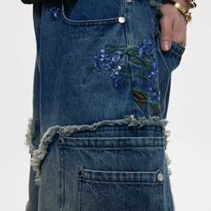 Close-up of intricate sequin embroidery on blue denim fabric.