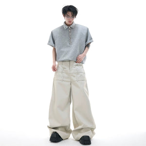 Close-up of safety pin hardware and sequin splicing on a white polo shirt.