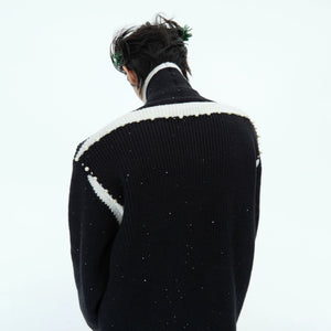 Detailed texture shot of the brushed shimmer knit material and asymmetric placket