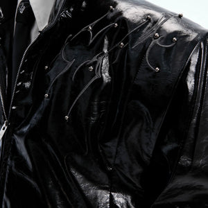 Macro shot of the 3D rivets and distressed hardware on the moto jacket