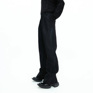 Front view of black deconstructed wide leg streetwear trousers with split cut design