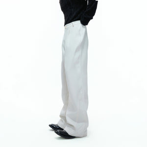 Model wearing black wide leg deconstructed trousers in an urban street setting