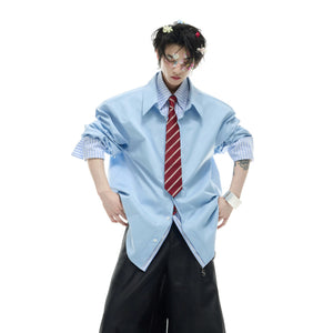 Side view of blue loose fit shirt with contrast striped sleeves.