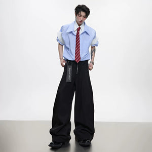 Close-up of the deconstructed patchwork and button details on the striped shirt.