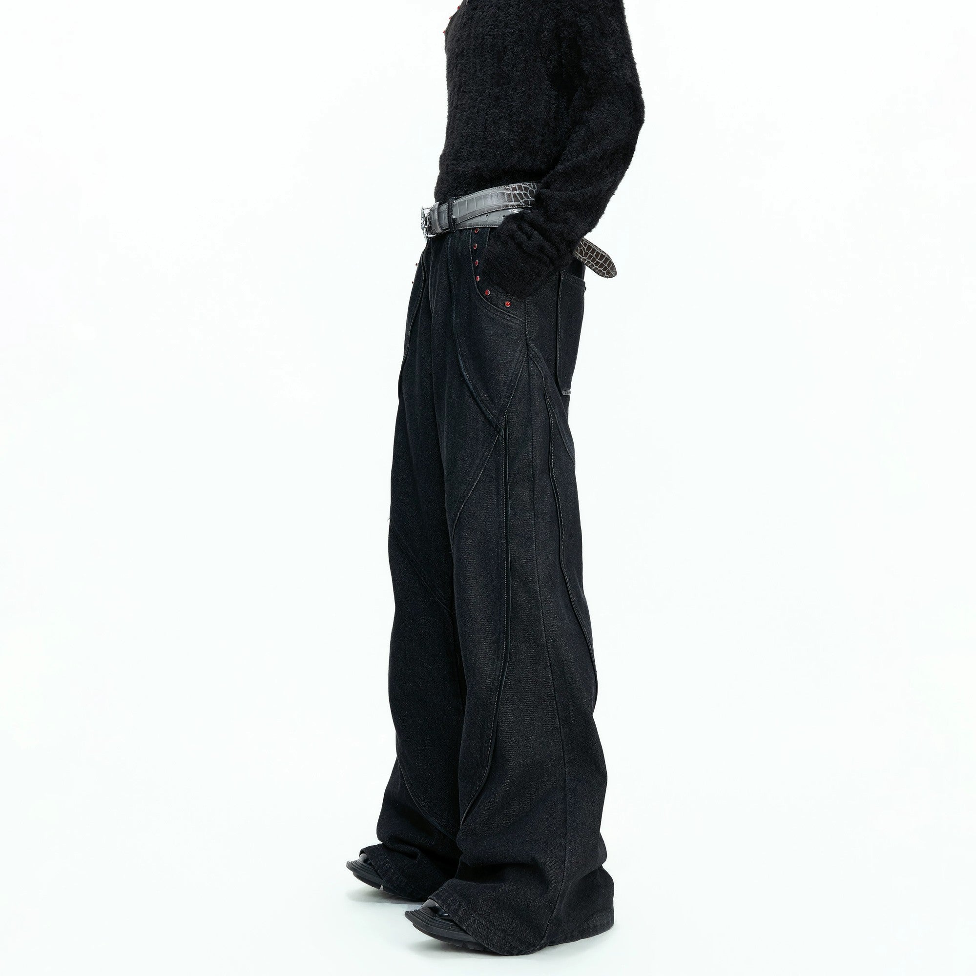 Close-up of red ruby rhinestone accents on black denim pocket