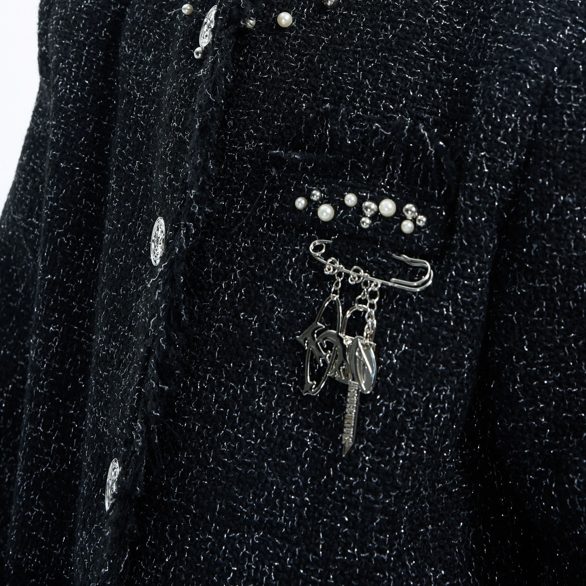 Styling shot of the metal logo pin on a black streetwear blazer