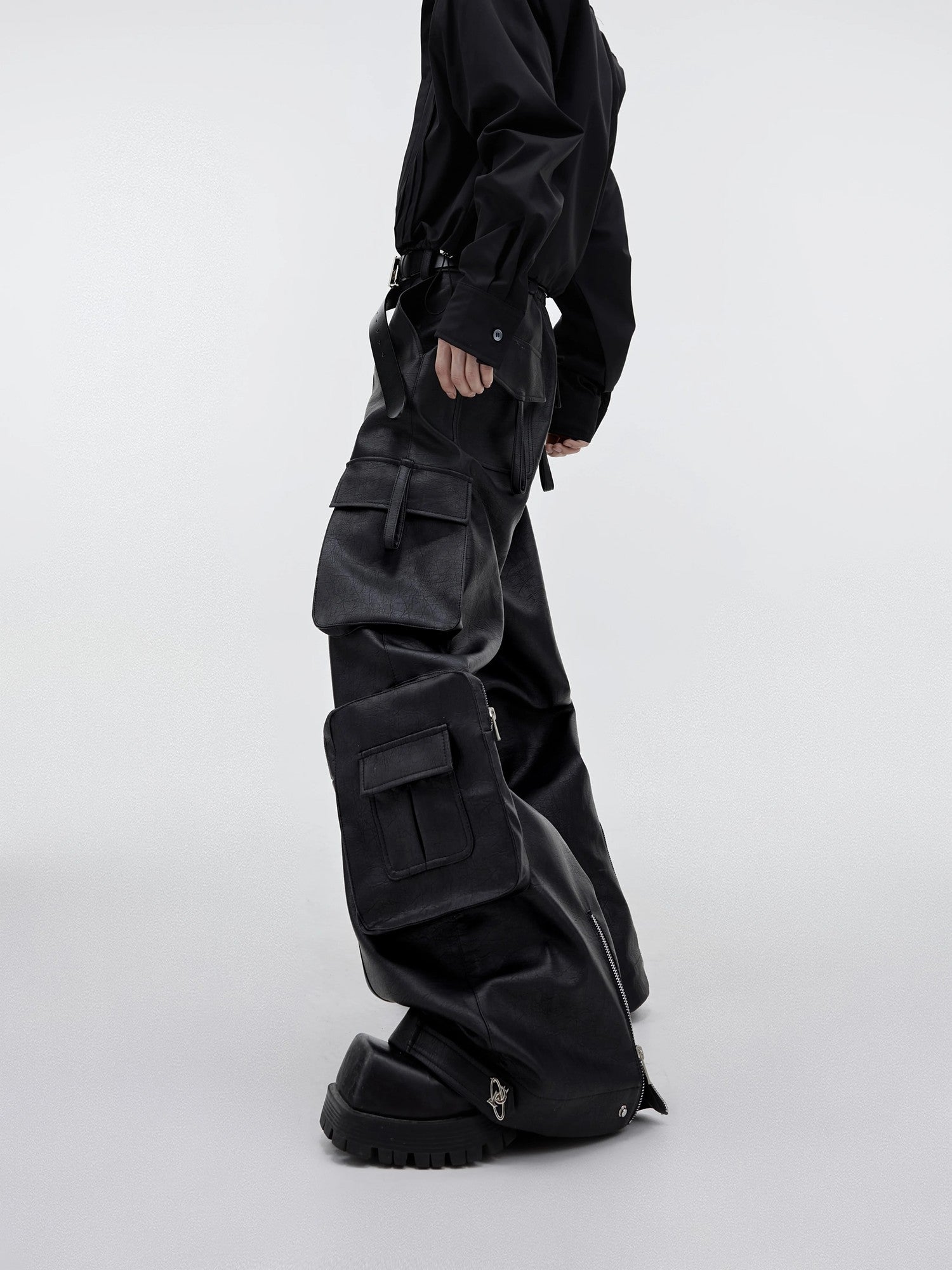Close-up of 3D oversized pockets and metal zipper details on leather pants