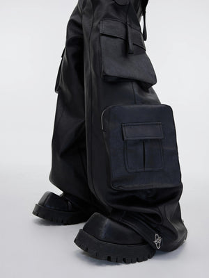 Model wearing black leather cargo pants in an urban street setting