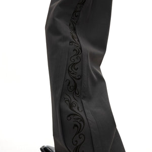 Close-up of the 3D cut pleats and embroidery detail on trousers.
