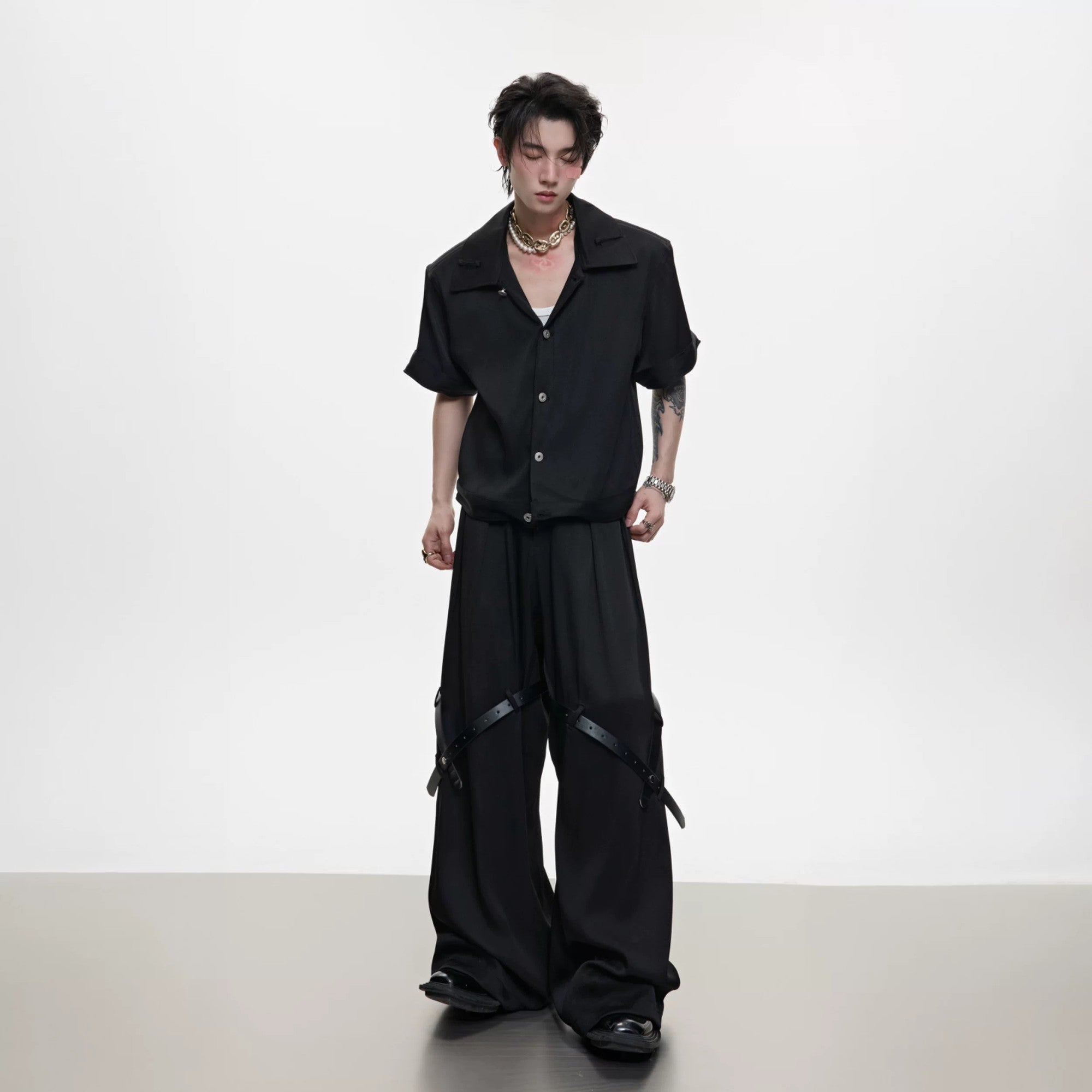 Detail of high-end trousers featuring industrial belt and metal buttons