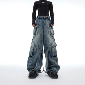 Front view of baggy blue distressed cargo jeans with raw edge straps