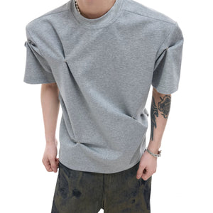 Street style model wearing a gray boxy deconstructed shirt with baggy pants