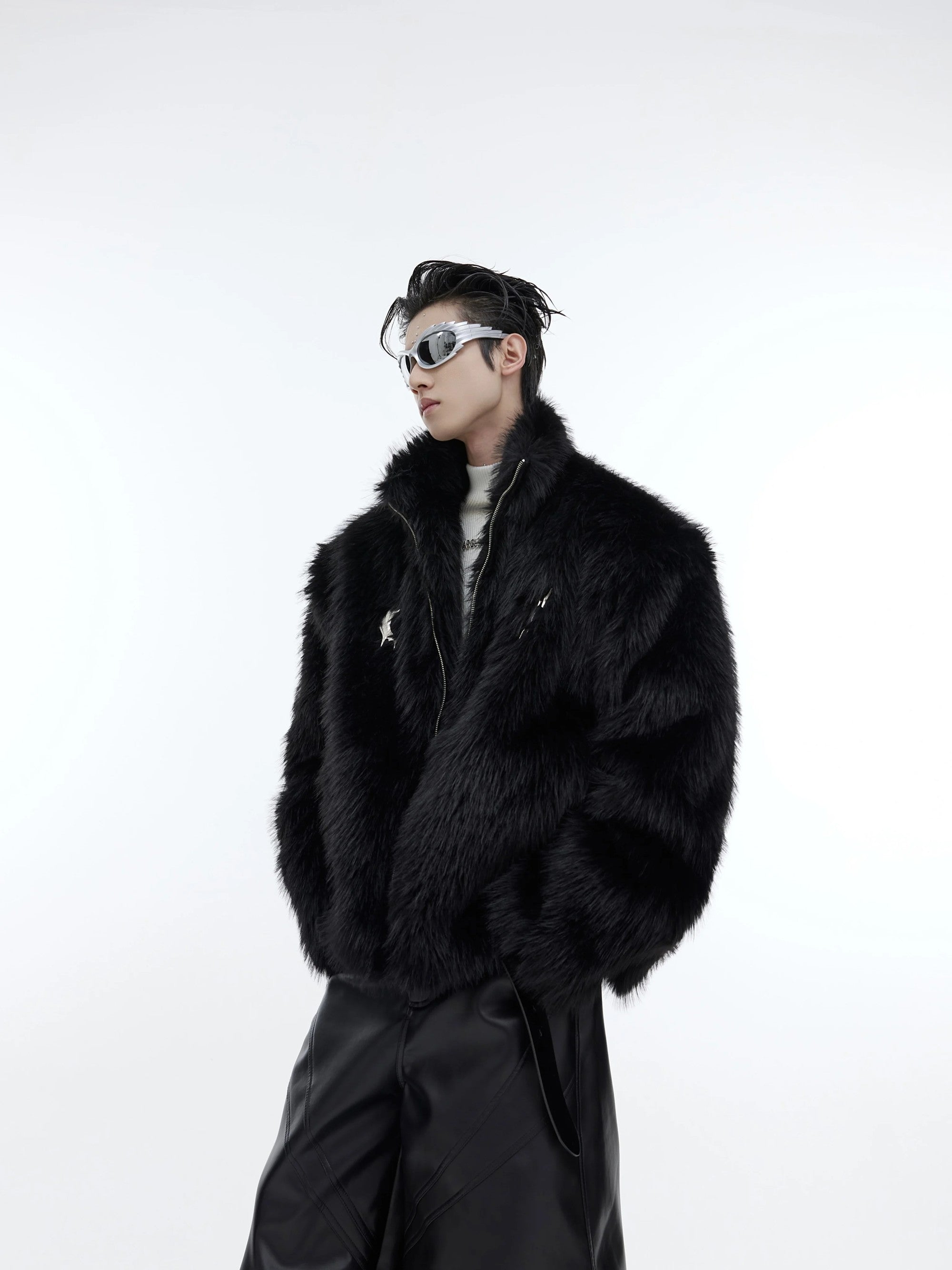Model wearing a black oversized faux mink fur jacket with metal details.