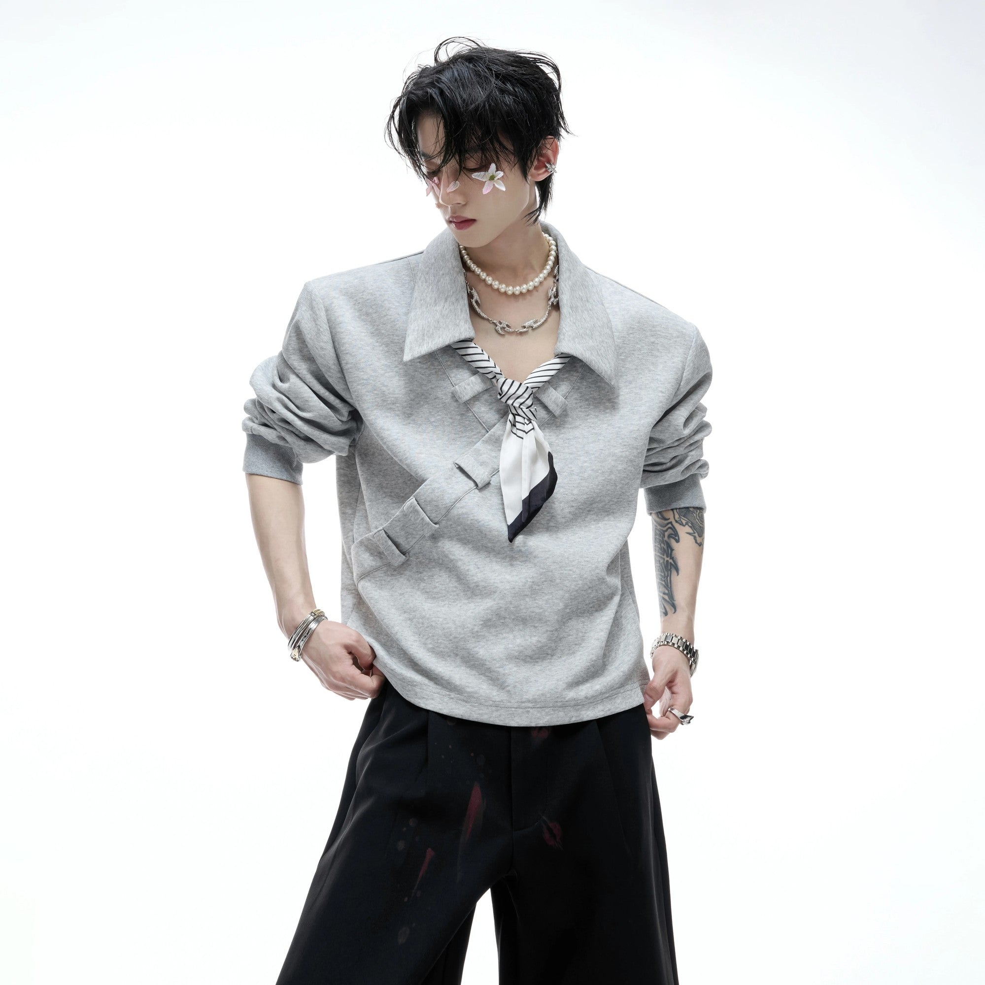 Model wearing gray boxy polo sweatshirt in street setting